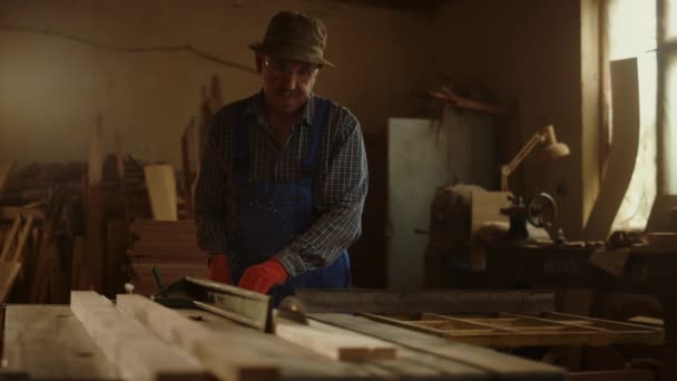 Starszy mężczyzna używający tokarki do drewna w warsztacie stolarskim. Złota rączka wytwarzająca drewno — Wideo stockowe