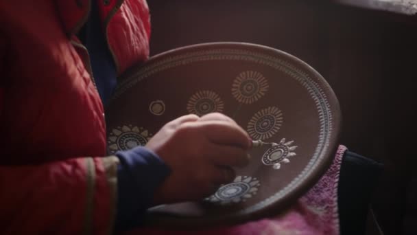 Unknown woman making decoration in workshop. Artist drawing ornament on plate — Stock Video