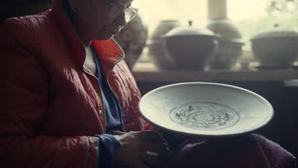 Senior ceramist folosind burete în studio. Femeie răzuire placă de lut în ceramică — Videoclip de stoc
