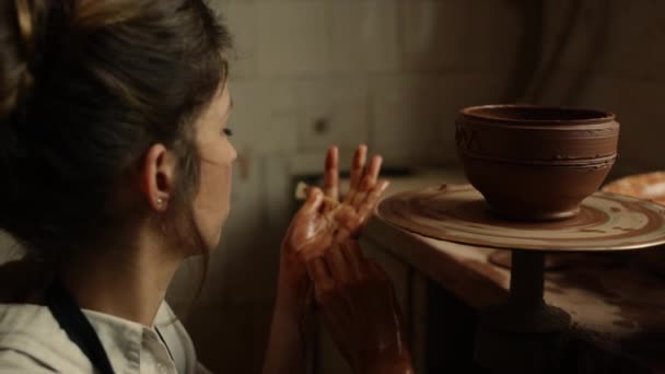 Mulher focada decorando panela de barro em cerâmica. Ceramista trabalhando com argila molhada — Vídeo de Stock