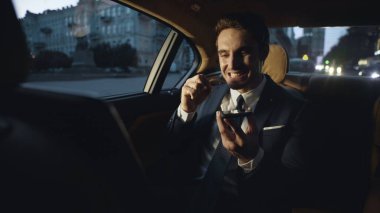 Koyu renk arabadaki cep telefonundan küfür eden kızgın iş adamı..