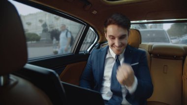 Lüks arabalarda dizüstü bilgisayarda iyi sonuçlar alan mutlu bir iş adamı..