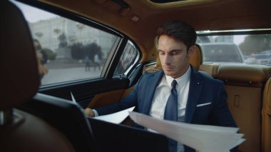 Otomobildeki belgelerde odaklanmış erkek profesyonel arama.