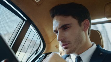 İş arabasındaki tablet bilgisayardaki erkek profesyonel okuma verilerini altüst et.