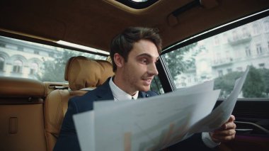 İş arabasında veri arayan mutlu bir iş adamı. Lüks arabadaki memnun adam.