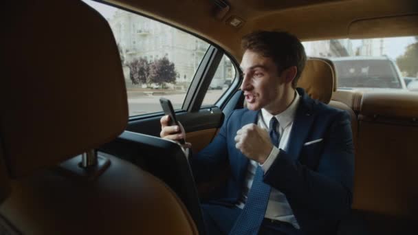 Heyecanlı iş adamı iş arabasında cep telefonuyla motivasyon videosu kaydediyor. — Stok video
