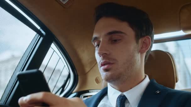 Πορτρέτο του εστιασμένου επιχειρηματία γραπτώς μήνυμα στο τηλέφωνο σε πολυτελή αυτοκίνητα. — Αρχείο Βίντεο