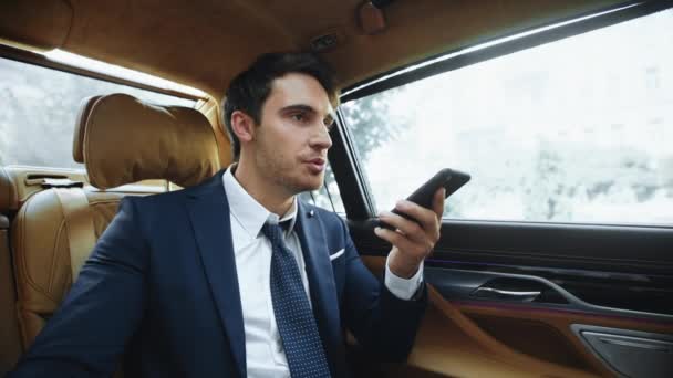 Stresowany mężczyzna profesjonalne nagranie wiadomości głosowej do smartfona w nowoczesnym samochodzie. — Wideo stockowe