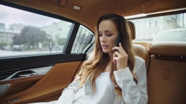 Modern araba kuaföründe cep telefonuyla konuşan duygusuz iş kadını..