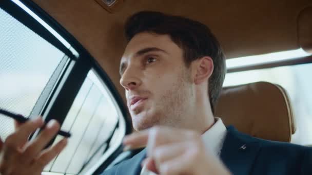 Ritratto di uomo d'affari rigoroso dettare messaggio vocale al telefono in auto moderna. — Video Stock