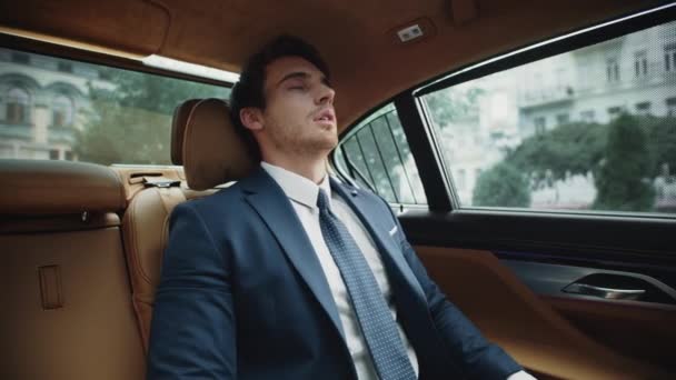 Retrato del hombre de negocios exhausto descansando en el asiento trasero del automóvil de lujo. — Vídeos de Stock