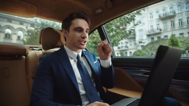 Ideges üzletember, aki videóhíváson beszél a kocsiban. Ceo vitatkozik a video chat — Stock videók