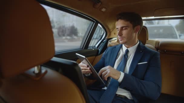Fokus męski profesjonalne dokumenty do czytania na tablecie cyfrowym w nowoczesnym samochodzie. — Wideo stockowe