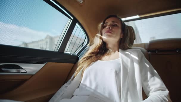 Dama de negocios agotada calmándose en el asiento trasero de un coche de lujo cómodo. — Vídeos de Stock