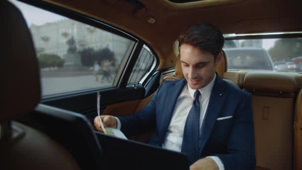 Joven profesional masculino mirando los documentos de datos en coche de negocios. Hombre en coche — Vídeos de Stock