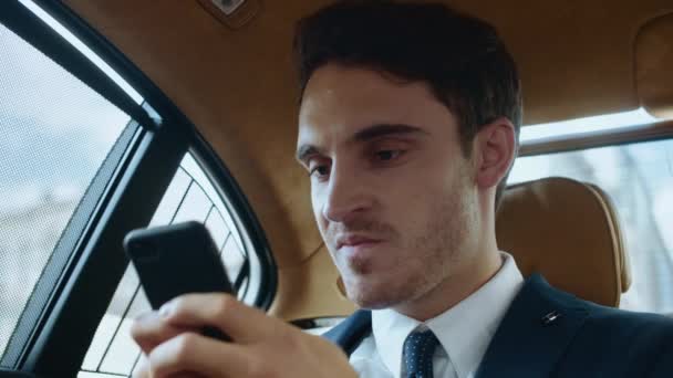 Ritratto di uomo d'affari infastidito che lavora con il telefono cellulare in automobile. — Video Stock