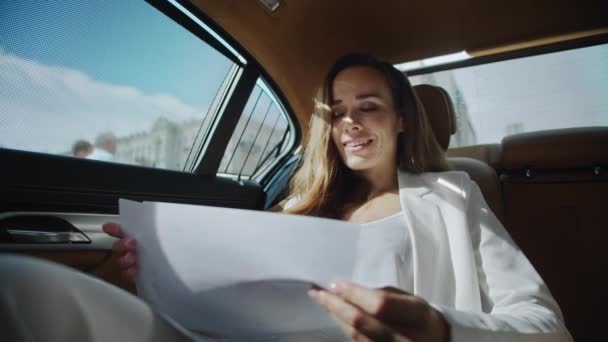 Весела ділова жінка аналізує статистику в документах автомобіля . — стокове відео