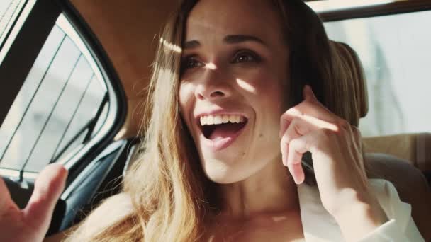 Щаслива бізнес-леді несподівано чути хороші новини по телефону в бізнес-автомобілі . — стокове відео