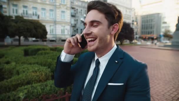 Portrait of happy business telling story on smartphone in city center. — Stok Video