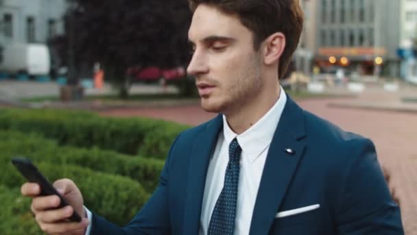 Ritratto di elegante uomo d'affari che scrive messaggio su smartphone in strada. — Video Stock