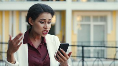 Karışık ırklı bir kadın açık havada projeyi açıklamakla meşgul. Bayan video arıyor.