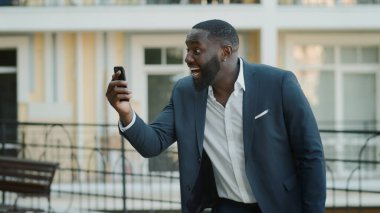 Afrikalı iş adamı sokakta iyi haberleri kutluyor. Mutlu afro işadamları