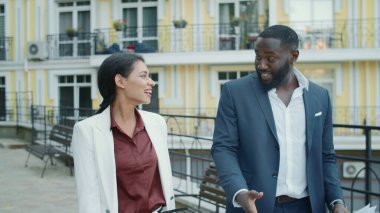 Şehir caddesinde yürüyen karışık ırk çifti. Dışarıda iki kişi konuşuyor.