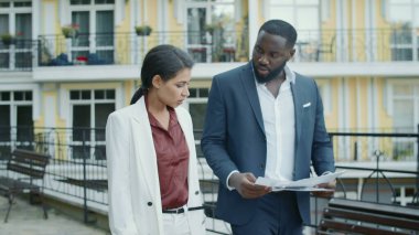 Ciddi bir iş çifti dışarıda belgeleri inceliyor. Dışarıda çalışan bir çift.