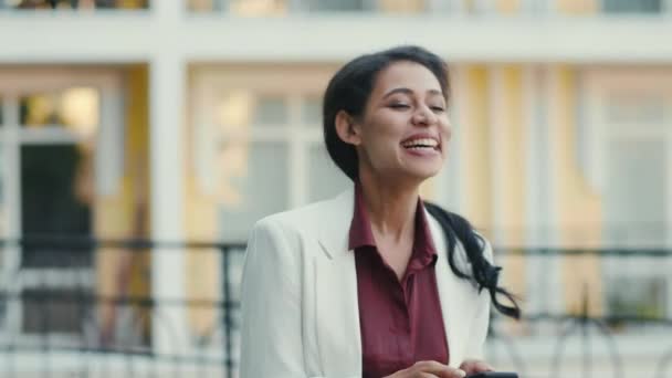 Riendo mujer de raza mixta recibiendo buenas noticias. Mujer de negocios celebrando la victoria — Vídeos de Stock