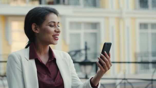 Mujer de negocios sonriente teniendo video chat afuera. Señora mirando pantalla del teléfono — Vídeos de Stock