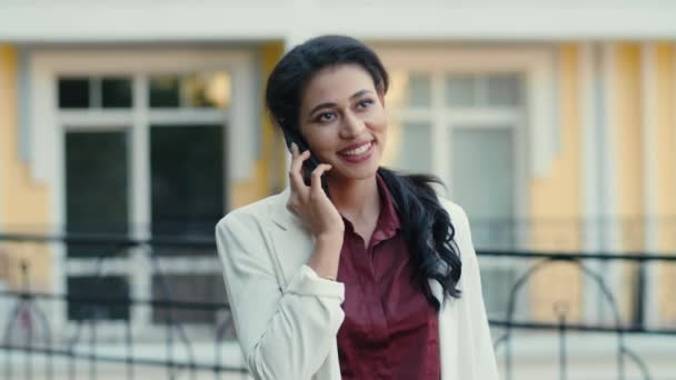 Feliz mujer de negocios de raza mixta hablando de teléfono celular afuera. Mujer llamando al aire libre — Vídeos de Stock