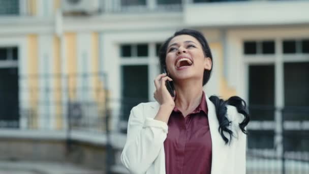 Donna di razza mista emotiva che ride al telefono all'aperto. donna che parla mobile — Video Stock