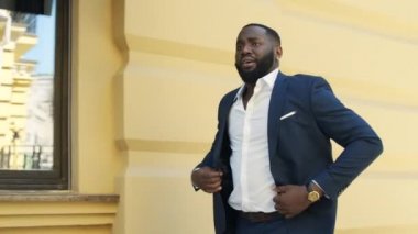 Afrikalı Amerikalı iş adamı aceleyle yürüyor. Afro adam şehir caddesinde hızlı gidiyor..