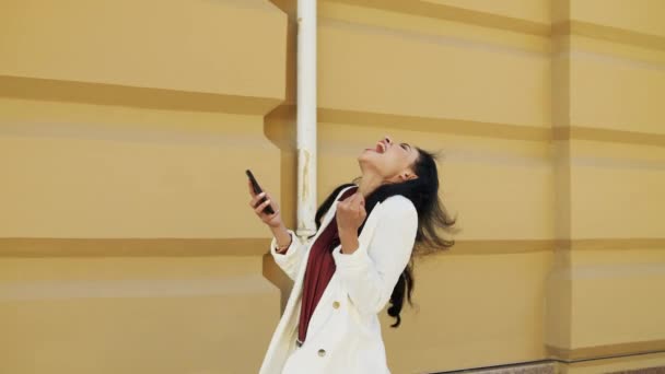 Gewinnerin Geschäftsfrau bekommt gute Nachricht auf Smartphone vor städtischem Hintergrund. — Stockvideo