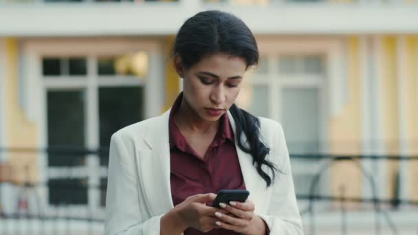 Serieuze zakenvrouw die buiten sms 't. Vrouw op zoek telefoon scherm — Stockvideo