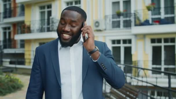 興奮したアフリカのビジネスマンが外に電話してきた。アフロ男がスマホを話す — ストック動画