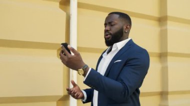 Ciddi bir afro adam video görüşmesi yapıyor. Afrikalı işadamı dışarıda telefonla konuşuyor..