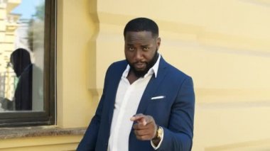 Afrikalı iş adamı duygusal konuşuyor. Dışarıda ağır çekimde yürümek.