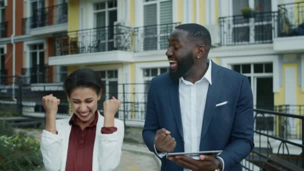 Pasangan bisnis merayakan di luar ruangan. Campuran ras orang mendapatkan kabar baik — Stok Video