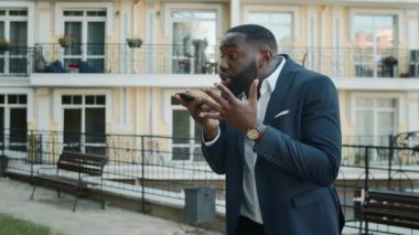 Dışarıdaki hoparlörden konuşan sinirli afro adam. İş adamı telefon görüşmesi yapıyor.