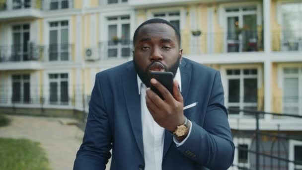 Zenuwachtige zakenman buiten aan het praten over mobiele telefoon. Afrikaanse man loopt buiten — Stockvideo