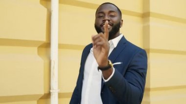 Genç afro iş adamı dışarıdaki kameraya bakıyor. Sokaktaki Afrikalı video blogcusu