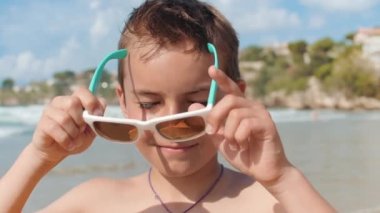 Neşeli çocuk kıyı şeridinde dinleniyor. Gülümseyen adam deniz kenarında yazın tadını çıkarıyor.