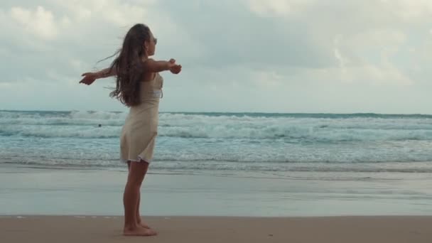 Glückliche junge Frau entspannt sich am Strand. Fröhliches Mädchen verbringt Sommer an der Küste. — Stockvideo