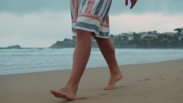 Unknown girl walking along beach. Barefoot woman spending vacation at beach. — Stock Video