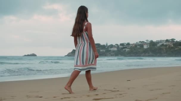 Beztroska dziewczyna odpoczywająca na piaskowej plaży. Młoda kobieta spacerująca nad morzem o zachodzie słońca. — Wideo stockowe