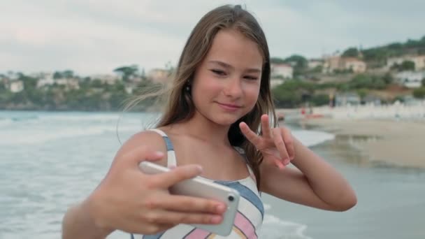 楽しい女の子は海辺で時間を過ごす。陽気な女性ポーズでカメラにビーチ. — ストック動画