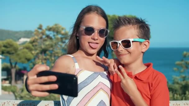 Joyful menino e menina sorrindo para câmera ao ar livre. Adolescentes desfrutando fim de semana. — Vídeo de Stock