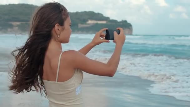 Счастливая девушка проводит летний отпуск у моря. Подростковые съемки на смартфоне. — стоковое видео