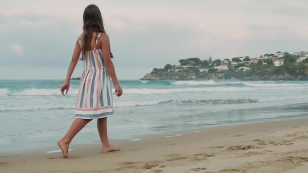 Ξέγνοιαστη γυναίκα που απολαμβάνει καλοκαιρινές διακοπές στην ακτογραμμή. Κορίτσι περπατά κατά μήκος της παραλίας. — Αρχείο Βίντεο